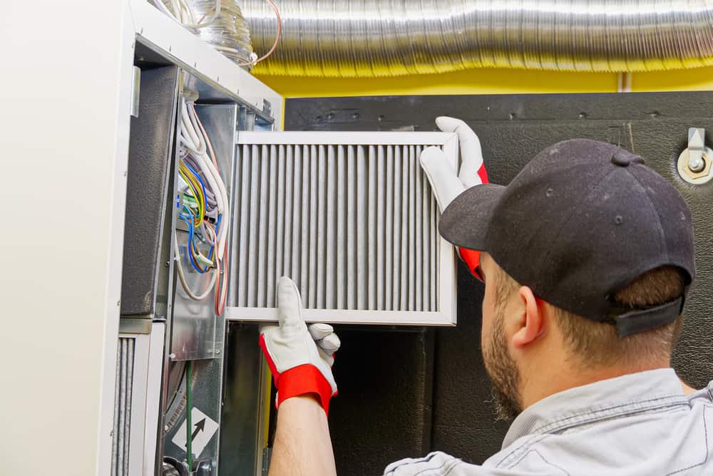 hvac technician working on filter.