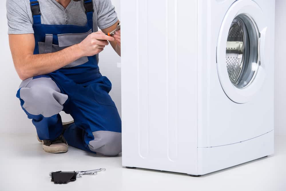 repairman working on washing machine. Appliance Repair Queens, NY