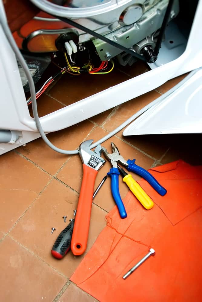 tools laying beside washing machine.