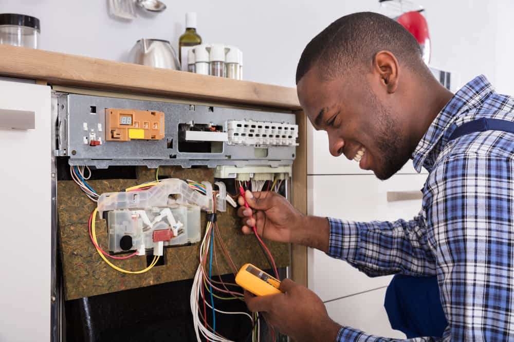 repairman working on dishwasher. Appliance Repair Queens, NY